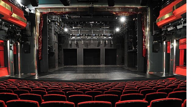 Empty Theater With Red Seats And Black Stage.