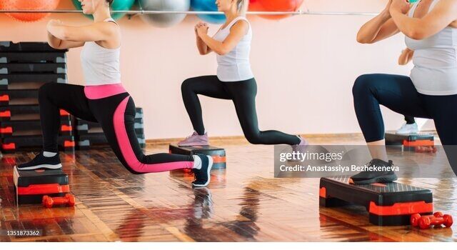 Group Of People Doing Step Aerobics In The Gym.